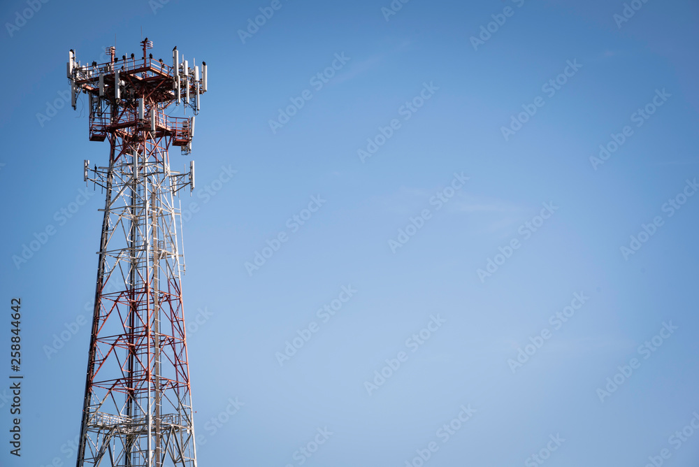 A metal cellular communications tower set on a clear blue sky background. A metal cellular communications tower set on a clear blue sky background.
