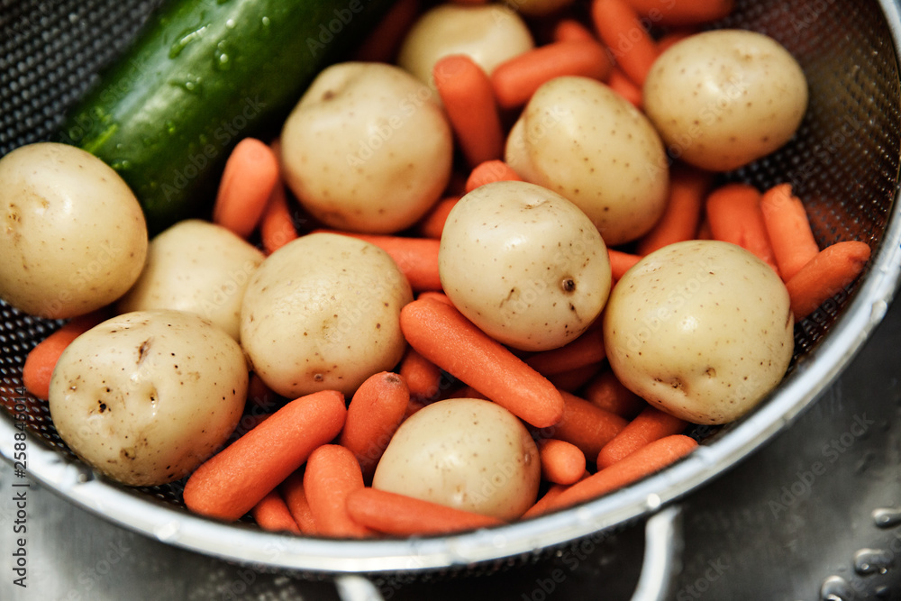 Organic potatoes and carrots washed before cooking in the kitchen, fresh vegetables, healthy eating concept Organic potatoes and carrots washed before cooking in the kitchen, fresh vegetables, healthy eating concept