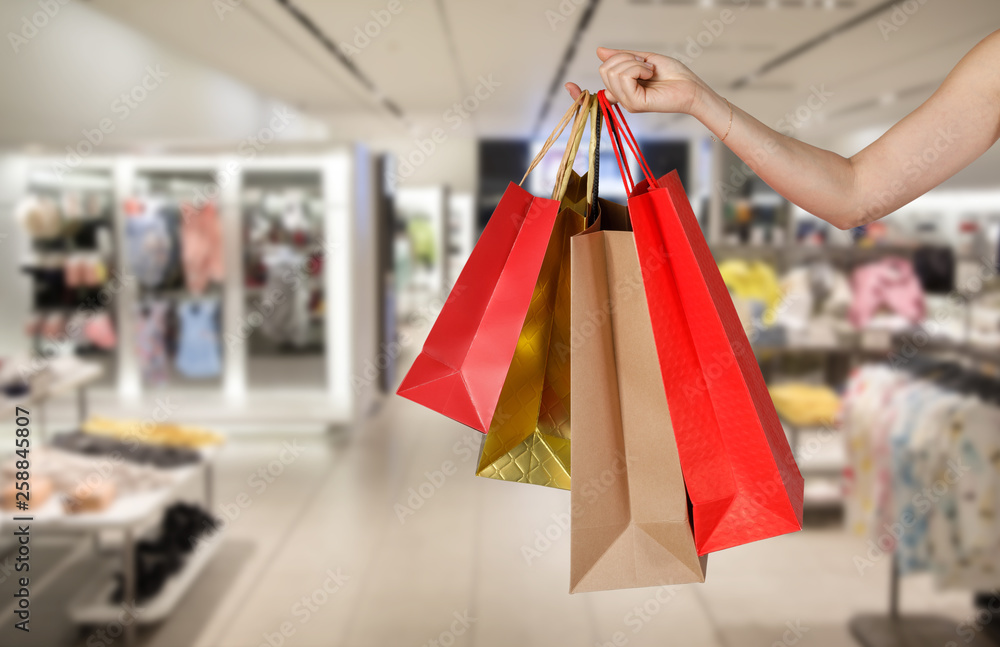 Shopping woman holding shopping bags in the mall store blurred background, E-commerce digital marketing lifestyle concept