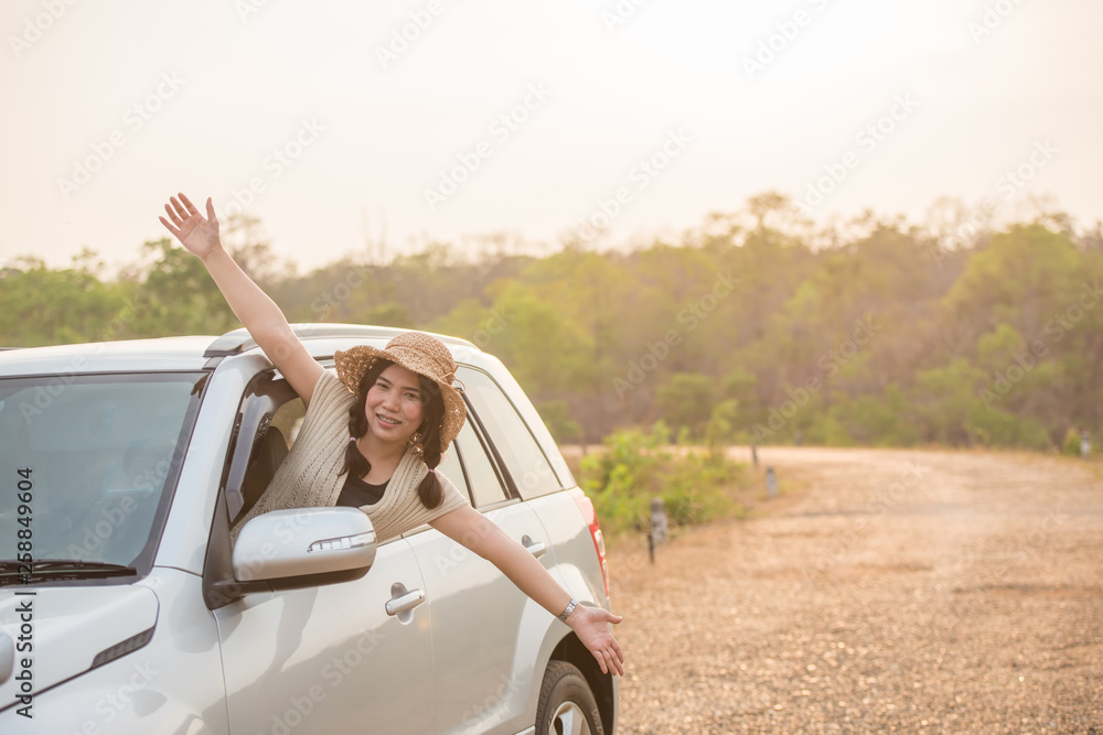 A beautiful woman very happy on the car on the road in the park A beautiful woman very happy on the car on the road in the park