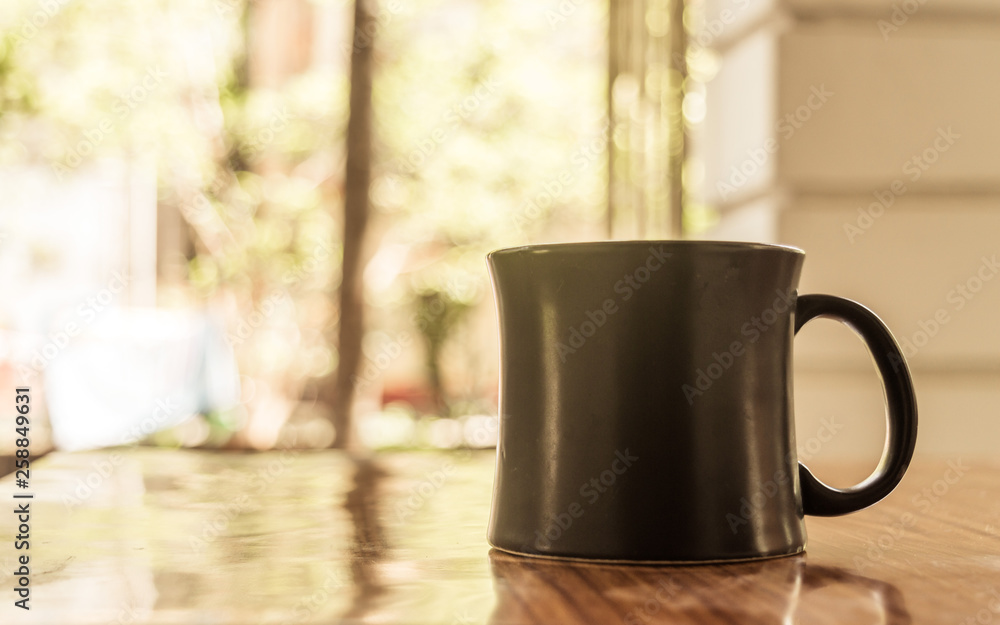 Fototapeta premium Closeup image of a cup of Cappuccino, mocha, latte, Americana, espresso hot coffee aroma for on rustic wooden table background in cafe with backdrop of sunlight light coming from window in morning.
