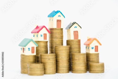 Mini house on stack of coins, isolated on white background, Concept of Investment property.