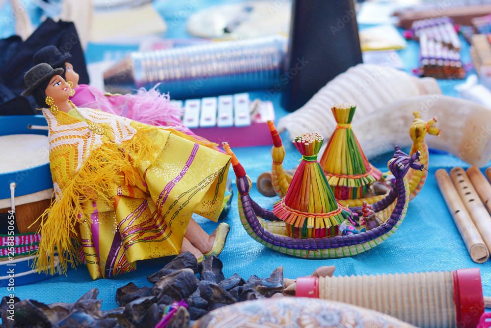 Fototapeta premium Doll with typical aymara clothes and two toy boats like from island Uros.