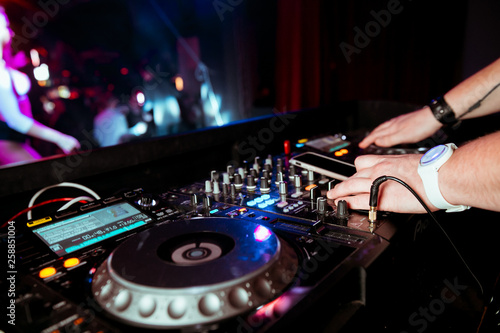 DJ remote on stage at the nightclub. background of dancing people.