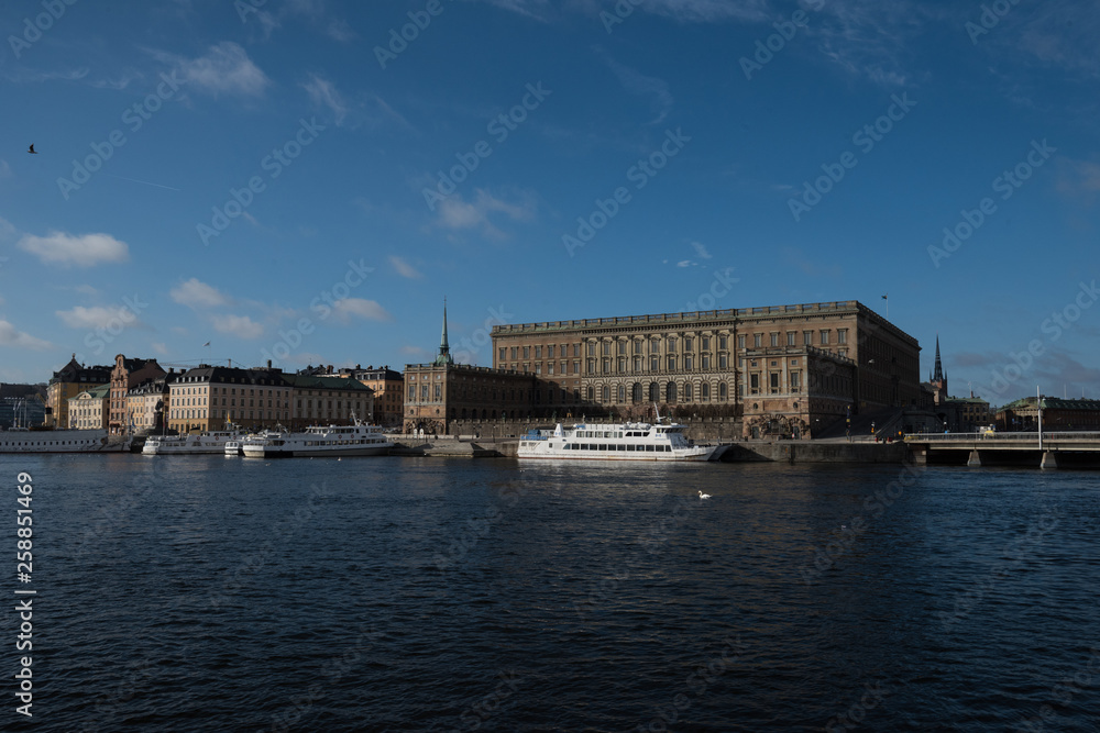 A sunny early spring day in Stockholm, view over a pier with boats and birds at the old town 