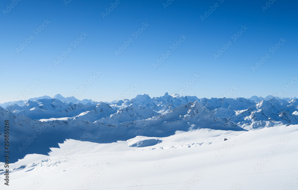 Snowy peaks of Caucasian Mountains in the blue sky. Elbrus region