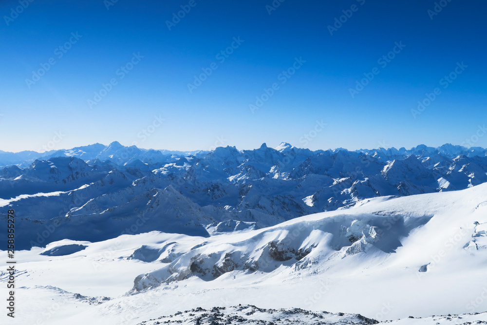 Mountain ranger of Caucasian Mountains in the blue sky. Elbrus region