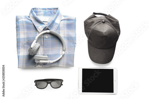 Shirt with cap, tablet PC, sunglasses and headphones on white background
