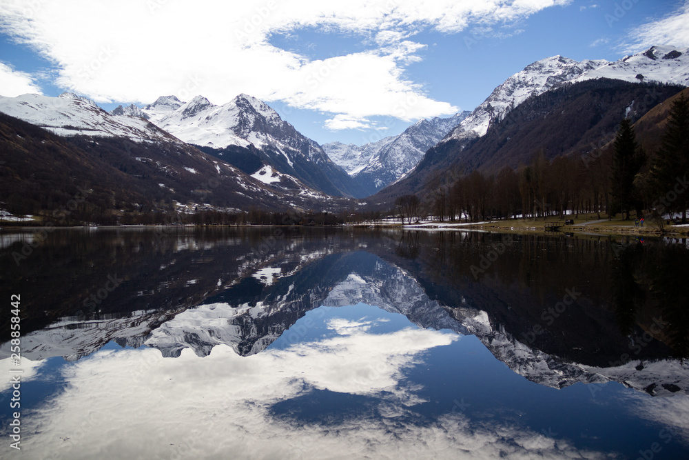 Snowy mountains reflecting in the calm mirror of a lake