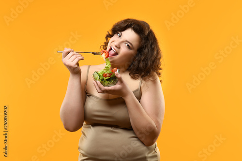 Overweight woman with salad...