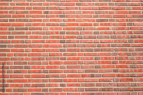 Red brick background with a thick layer of cement, a fragment of a brick wall