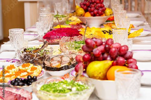 Snacks, fruits, sandwiches, salads, caviar and slicing on the holiday table