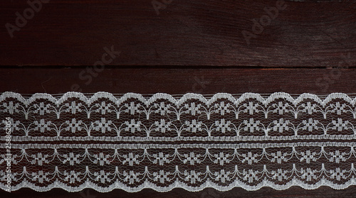 White lace on dark brown wooden background