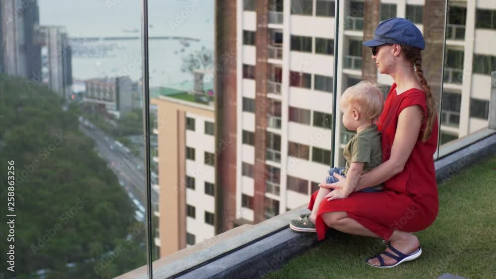 Household family scene where mom shows to her child a view of the urban landscape. Pattaya, Thailand. Household family scene where mom shows to her child a view of the urban landscape. Pattaya, Thailand.