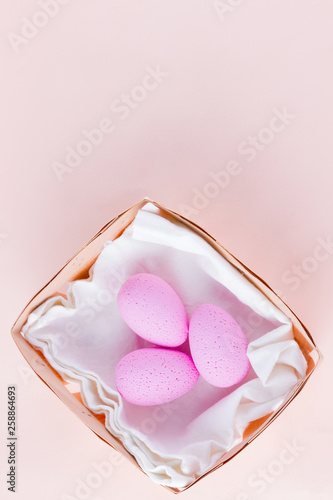 Pink easter eggs in wooden basket. Easter minimal concept. Eggs in box on a pink background. Flat lay