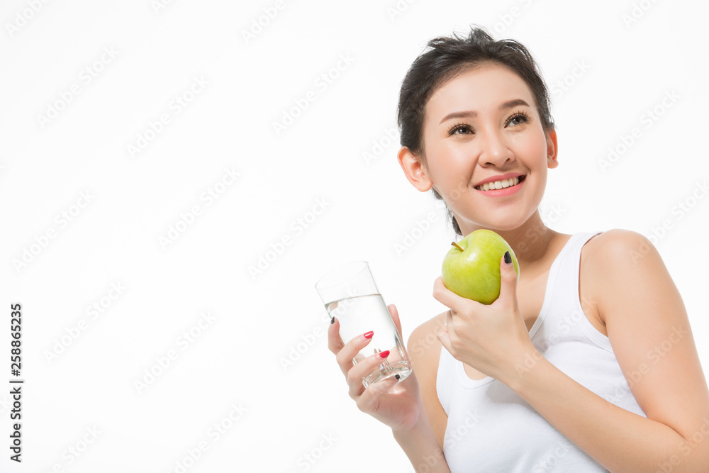 young woman holding green apple and glass of water isolated over white background young woman holding green apple and glass of water isolated over white background