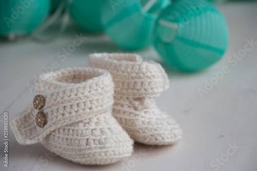 Newborn baby booties  beige  cozy and nice. Child clothe and boots - knitted and sweet. Text space  copy past and place for your design