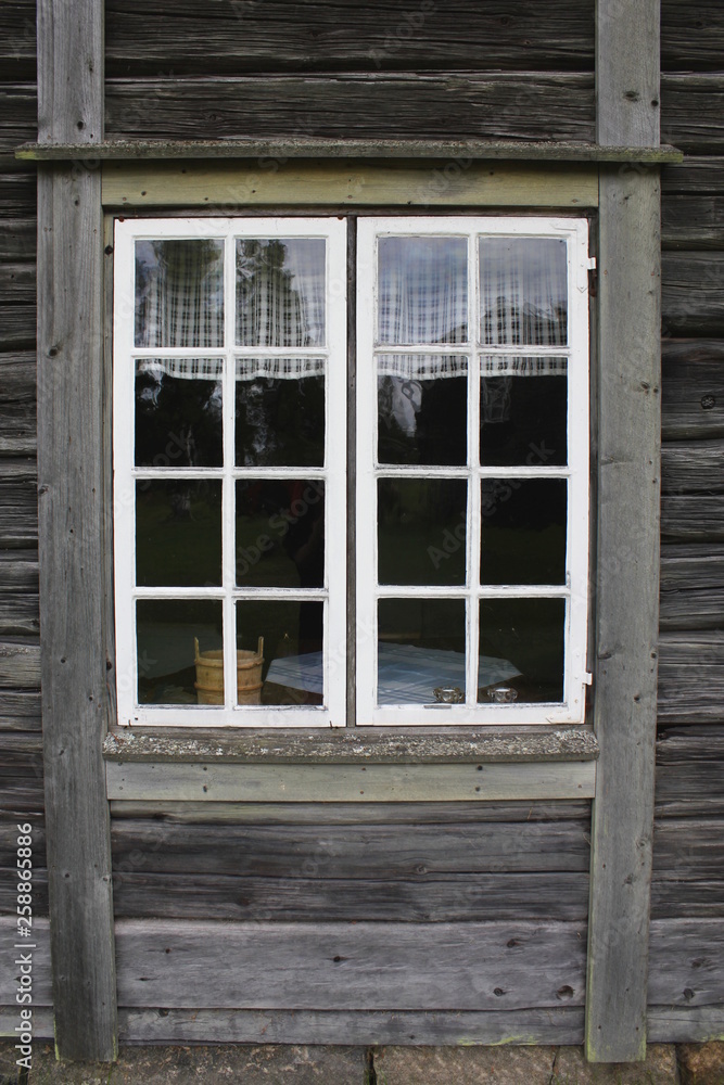 A window on a old grey wooden house in Sweden