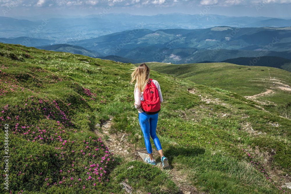 woman traveler,  girl with backpack in walking mountains summer outside