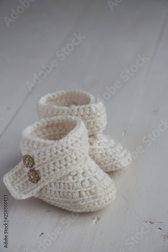 Newborn baby booties, beige, cozy and nice. Child clothe and boots - knitted and sweet. Text space, copy past and place for your design