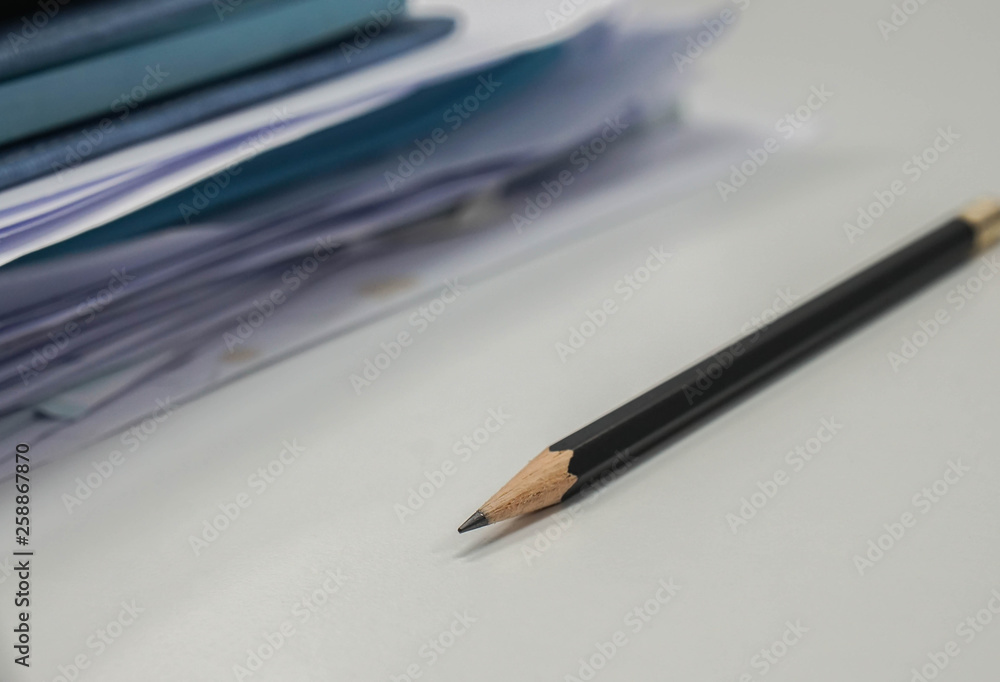Fototapeta premium selective focus sharp pencil with business documents pile on office desk