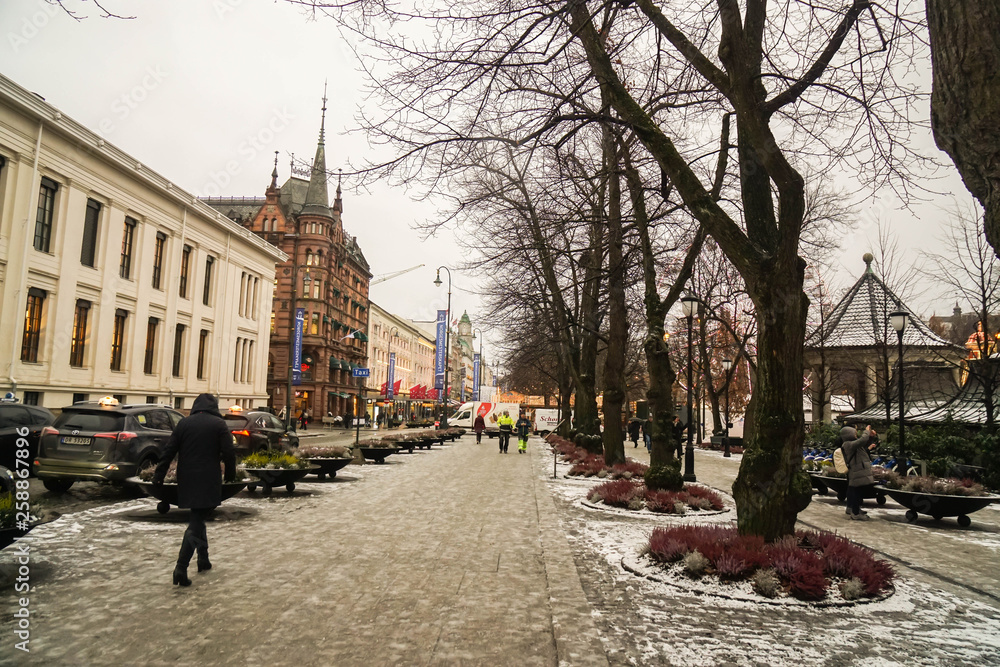 Oslo / Norway - December 1 2018: people walk on footpath to enjoy their holidays in Oslo in snowy day in winter