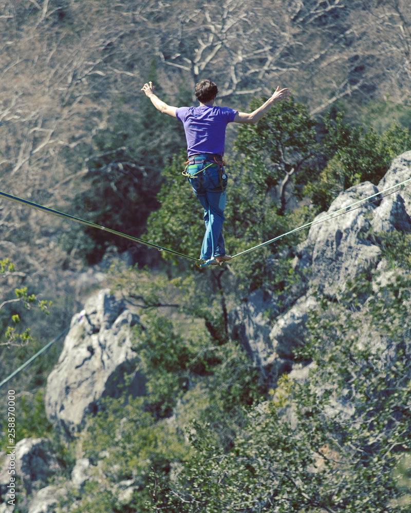 Fototapeta premium Man balancing on the rope concept of risk taking and challenge.