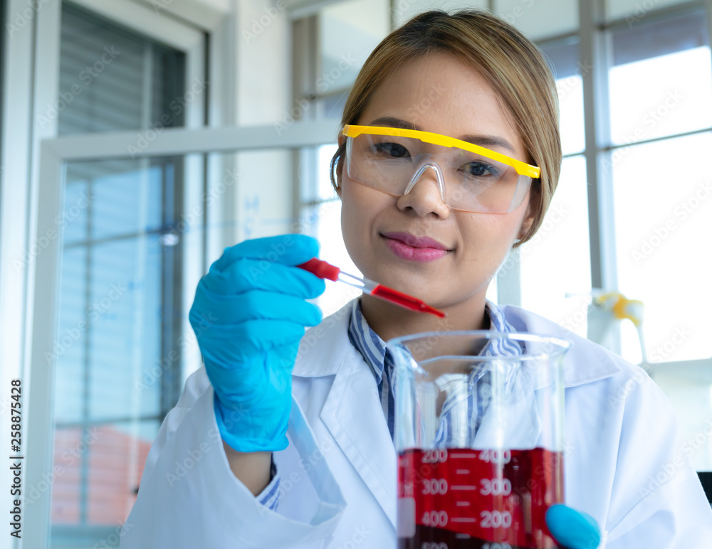 Young female doing experiments and researchers working in the laboratory. Young female doing experiments and researchers working in the laboratory.