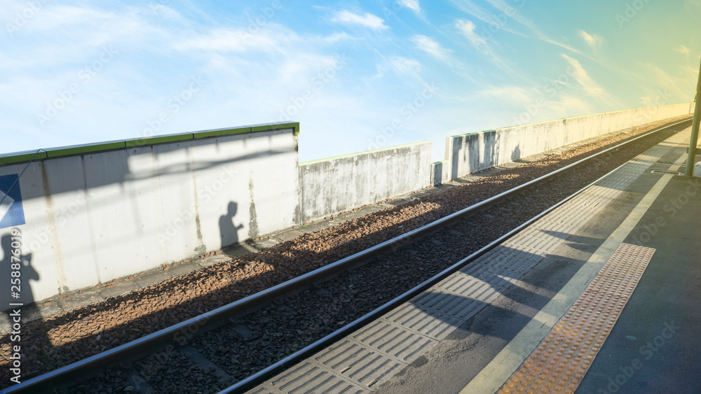 the shadow of the person above the morning railroad line