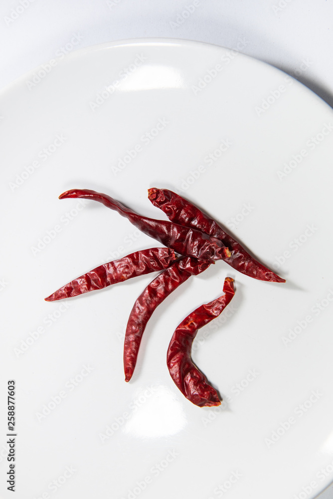 Dried chillies on white plate Dried chillies on white plate