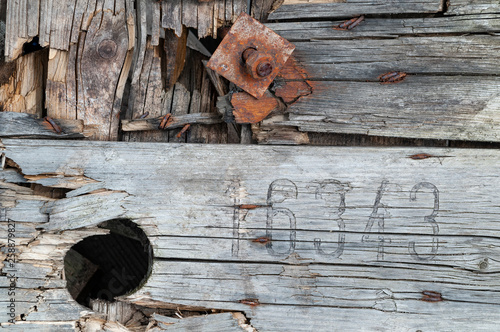 Background, damaged construction out of weathered wood plancs with rusty screws photo