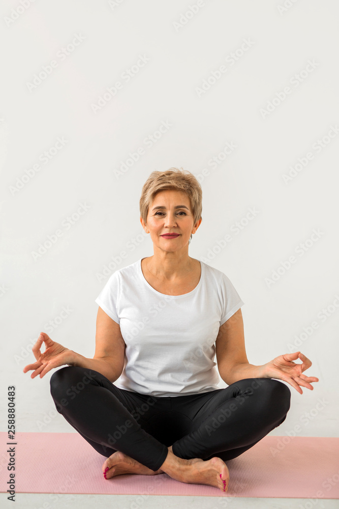 stylish elderly woman doing yoga on a white background stylish elderly woman doing yoga on a white background