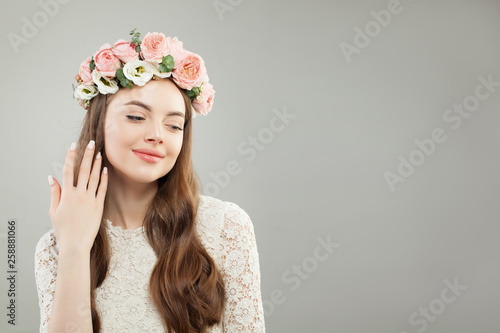 Natural Beauty. Beautiful Model Woman with Long Curly Hair, Healthy Skin, Natural Nude Makeup and Flowers