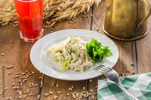 salad with chicken and cabbage and glass of berry drink on wooden table