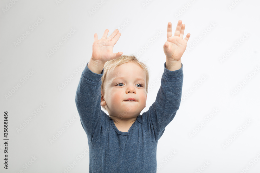 Little boy holding his hands up in the air. Studio shot Little boy holding his hands up in the air. Studio shot