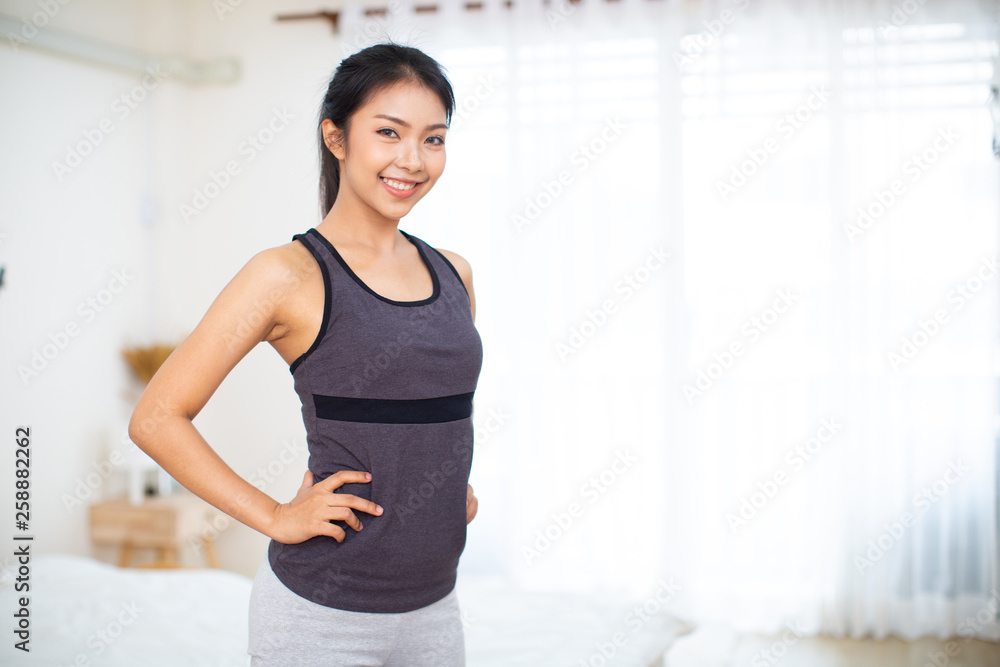 Sporty beautiful woman exercising at home to stay fit