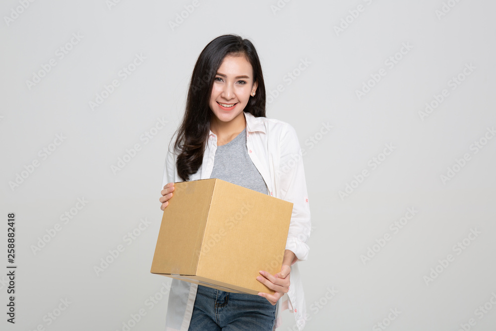 Delivery, relocation and unpacking. Smiling young woman holding cardboard box isolated on white background Delivery, relocation and unpacking. Smiling young woman holding cardboard box isolated on white background