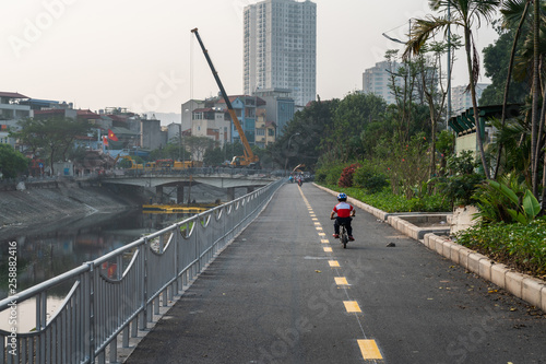Little boy riding bike on empty road in city