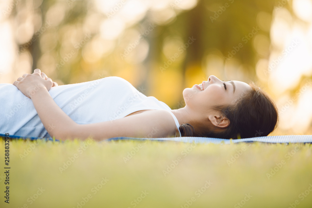 Beautiful young woman laying on grass in park Beautiful young woman laying on grass in park