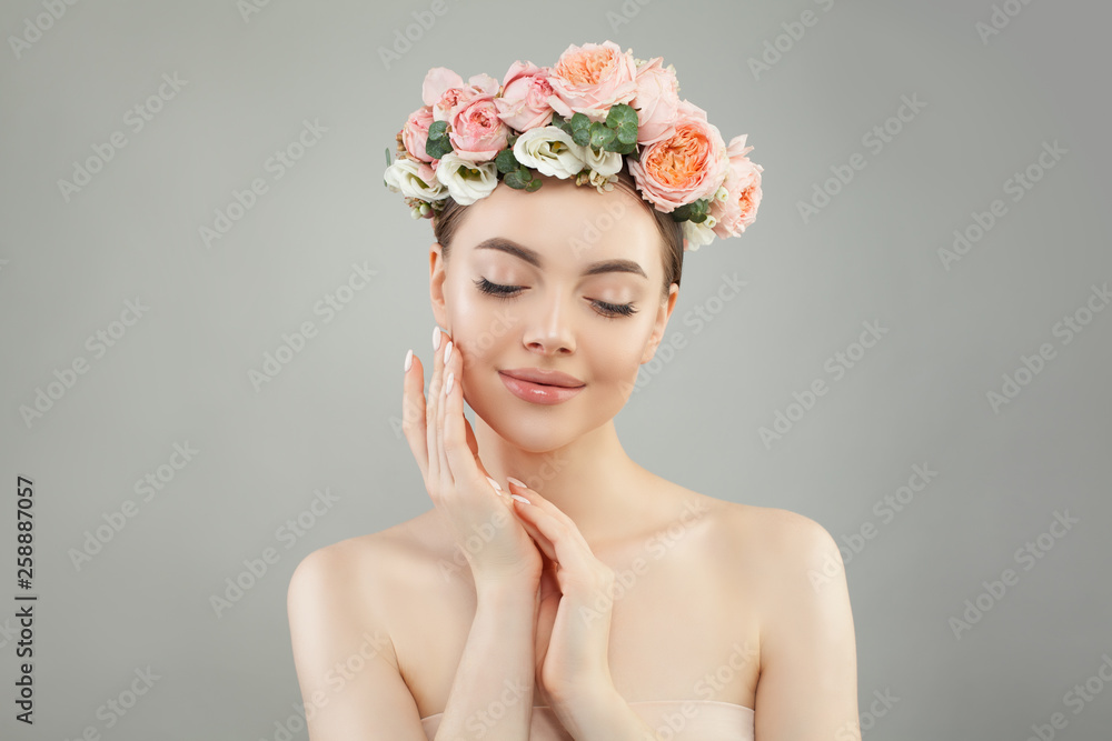 Perfect young woman with clear skin and flowers on her head. Facial treatment, cosmetology and skin care concept