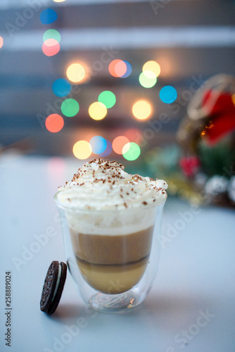 Coffee drink with milk and cookies on the table. Bokeh lights.