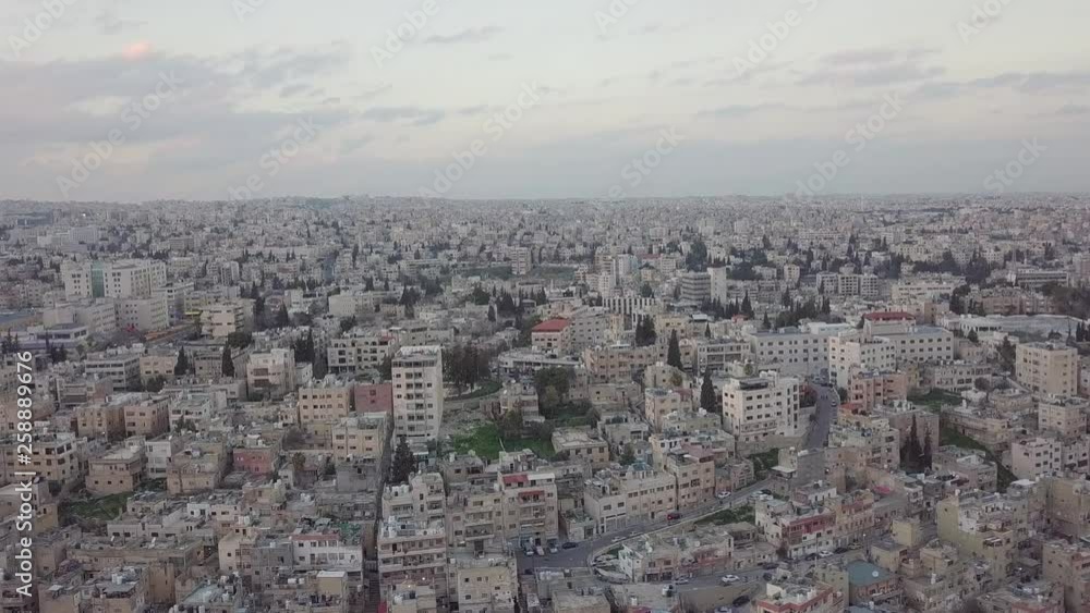 Serene early morning in Amman Jordan taken by a drone slowly descending and moving with a flock of pigeons flying by Serene early morning in Amman Jordan taken by a drone slowly descending and moving with a flock of pigeons flying by