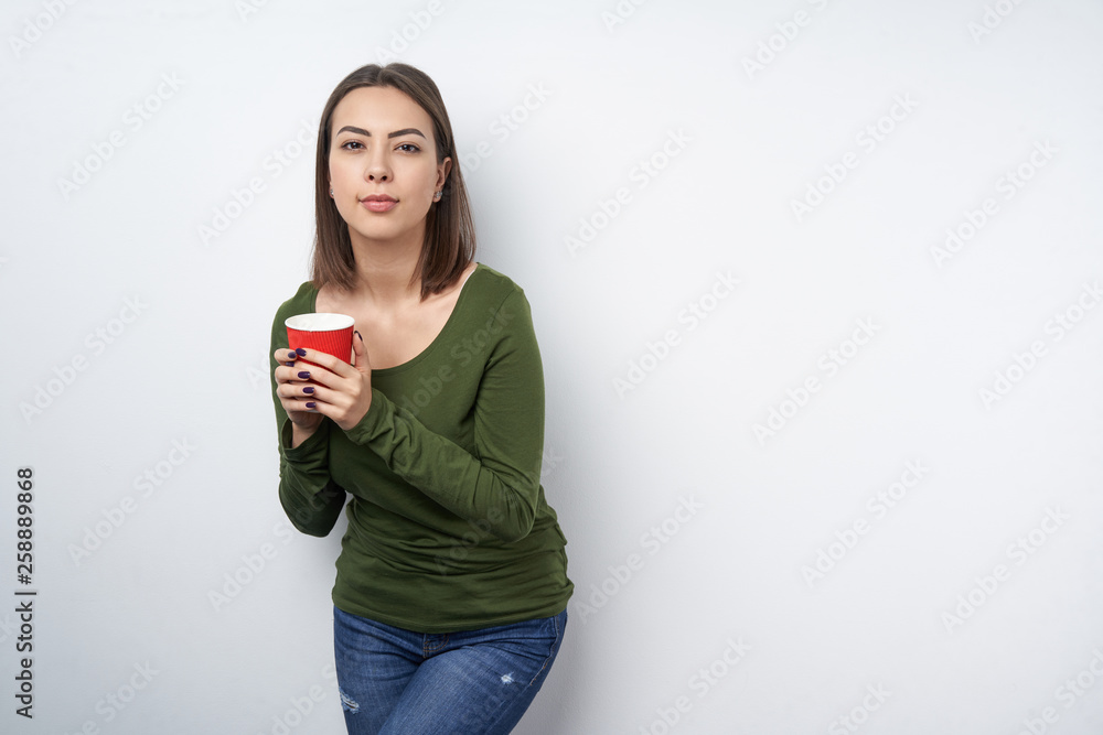 Calm brunette woman holding disposable paper mug Calm brunette woman holding disposable paper mug