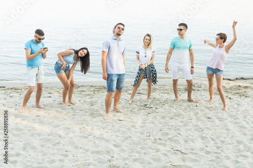 Group of happy young people on the sand outdoors