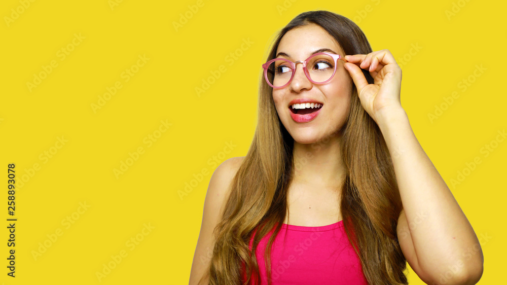 Excited woman looking sideways screaming of joy. Closeup of happy fashion girl isolated on yellow background. Excited woman looking sideways screaming of joy. Closeup of happy fashion girl isolated on yellow background.