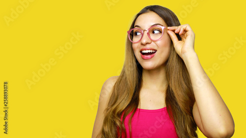 Excited woman looking sideways screaming of joy. Closeup of happy fashion girl isolated on yellow background.