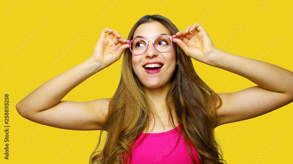 Funny portrait of excited girl wearing glasses eyewear. Closeup portrait of  young woman making funny face expression isolated on yellow background.  Beautiful young model. Stock Photo | Adobe Stock