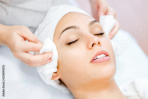 Cosmetologist hands cleanse the skin. Facial skin care. Beautiful ltdeirf on cosmetology procedure. Beauty salon visit.