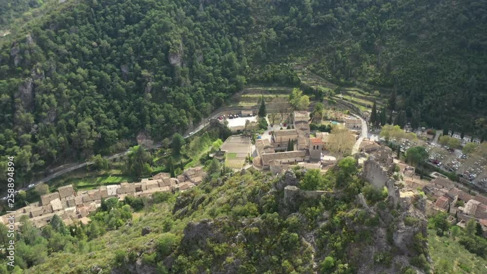 Aerial drone view flying around castle ruins with Saint Guilhem le Desert medieval villages in background Aerial drone view flying around castle ruins with Saint Guilhem le Desert medieval villages in background