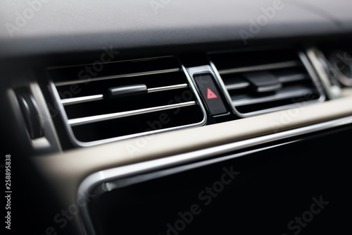 Modern car interior with close-up of ventilation system holes and air conditioning -